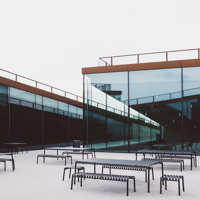 A wide angle shot of several tables put in front of a glass building